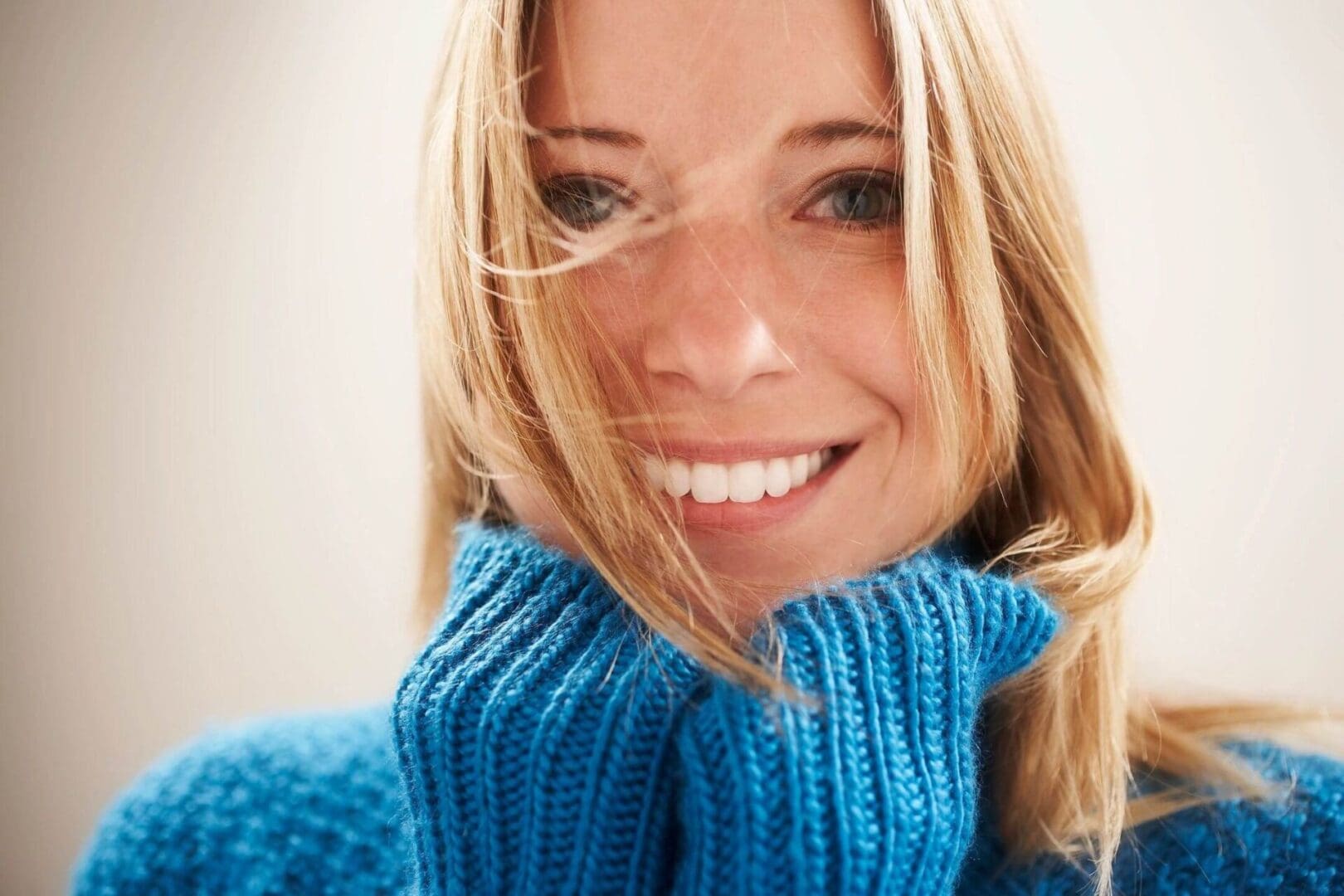 A woman in blue sweater smiling for the camera.