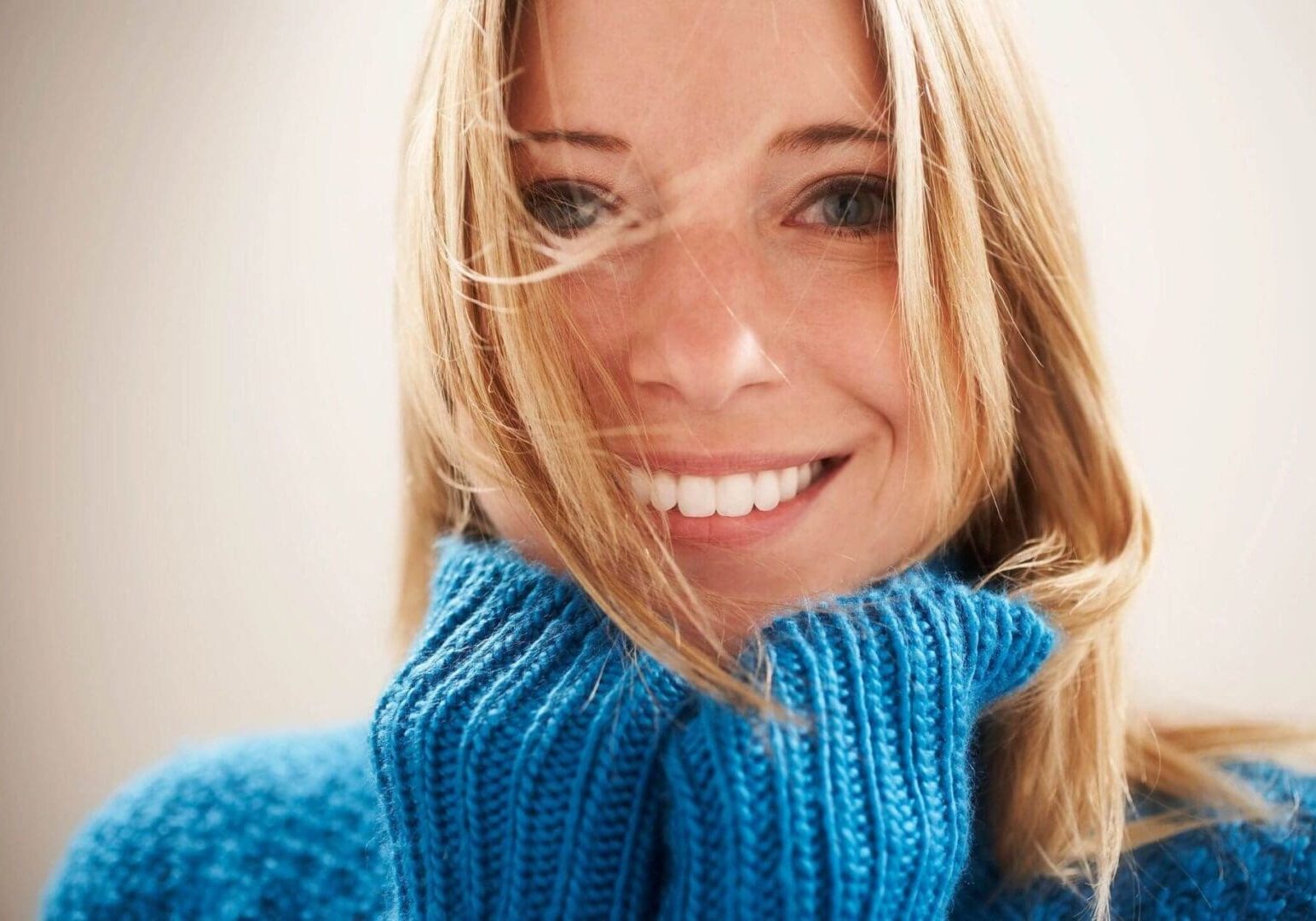 A woman in blue sweater smiling for the camera.